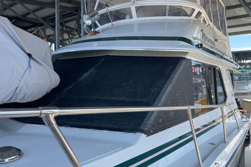 Slide: The Image of 1988 Chris-Craft 392 Sport Fish boat docked, featuring sleek design and covered windows. - 38