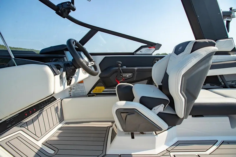 Slide: The Image of 2022 Nautique Super Air Nautique G25 interior with sleek steering and modern seating. - 12