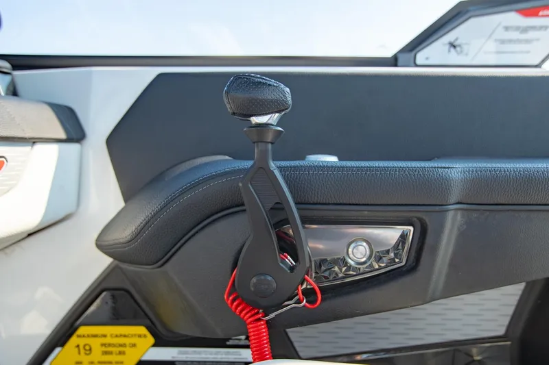 Slide: The Image of 2022 Nautique Super Air Nautique G25 throttle control with sleek design and red safety cord. - 15