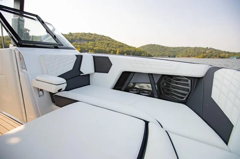 Slide: The Image of 2022 Nautique Super Air Nautique G25 interior with luxurious seating and scenic lake view. - 22