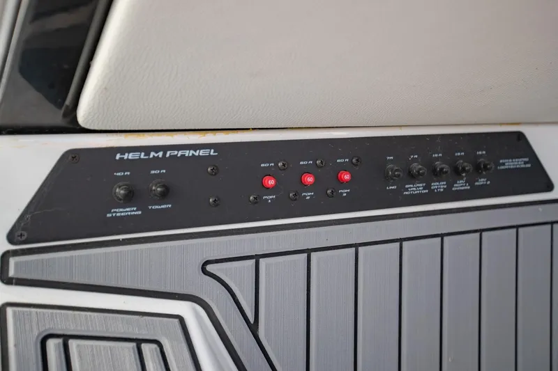 Slide: The Image of Helm panel of 2022 Nautique Super Air Nautique G25 boat, featuring various controls and switches. - 38