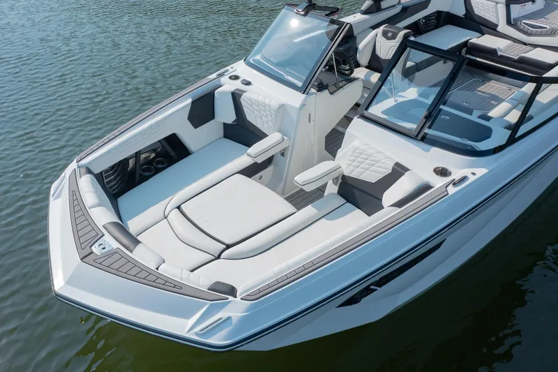 Slide: The Image of 2022 Nautique Super Air Nautique G25 boat with luxurious seating on calm water. - 6