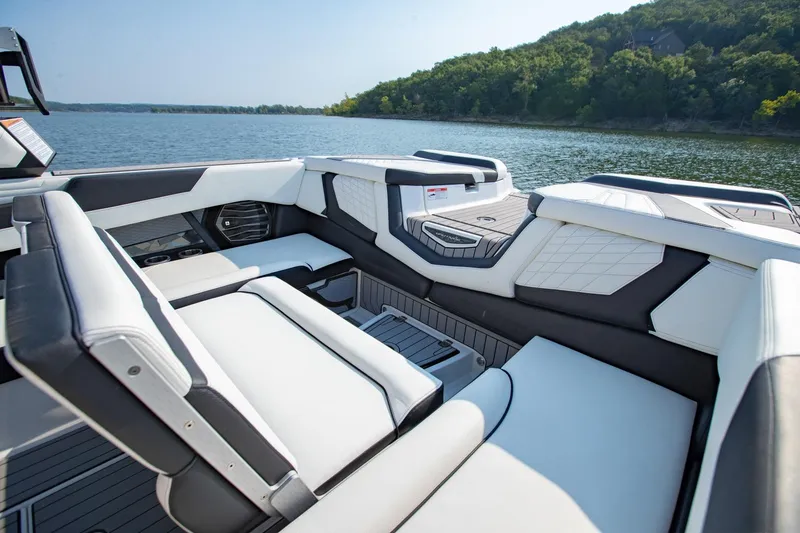 Slide: The Image of 2022 Nautique Super Air Nautique G25 interior with luxurious seating on a serene lake. - 9