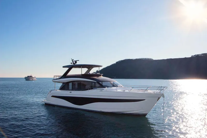 Slide: The Image of 2025 Princess Y72 Motor Yacht cruising on serene waters under a bright sun. - 1