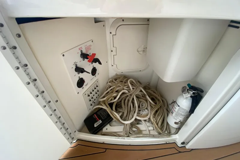 Slide: The Image of Storage compartment of a 2004 Formula 370ss boat with ropes and fire extinguisher. - 12
