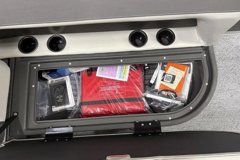 Slide: The Image of Storage compartment of 2026 Sun Tracker Bass Buggy 16 XL Select with manuals and safety gear. - 12
