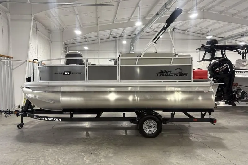 The Image of 2026 Sun Tracker Bass Buggy 16 XL Select pontoon boat in a showroom. - 2