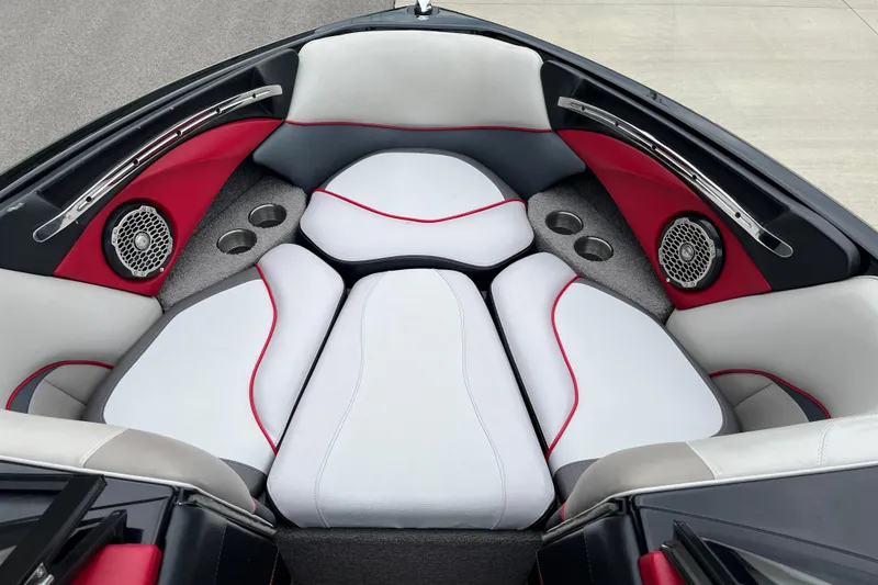 Slide: The Image of 2013 Malibu Wakesetter 23 LSV boat interior with white and red seating, speakers, and cup holders. - 8