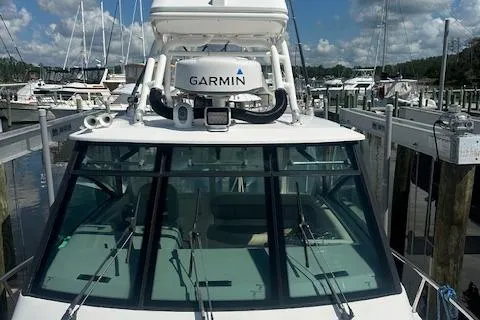 Slide: The Image of 2011 Everglades 320 EX with Tower, docked, featuring Garmin equipment, surrounded by other boats. - 1
