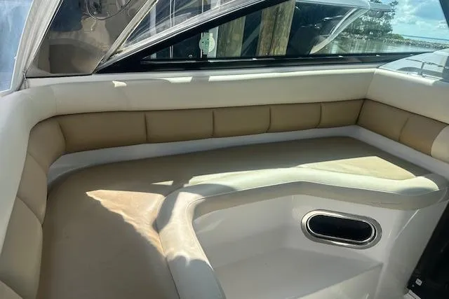 Slide: The Image of 2011 Everglades 320 EX boat interior with beige seating and window view. - 8