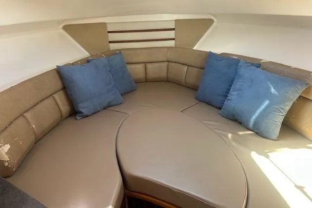 Slide: The Image of Interior of 2011 Everglades 320 EX boat with beige seating and blue cushions. - 9