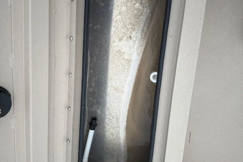 Slide: The Image of Interior view of 2026 Avid 16 Commander boat, featuring a compartment with water and a drain. - 13