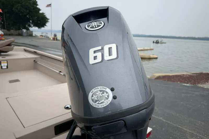 Slide: The Image of Outboard motor on Avid 16 Commander boat, 2026 model, near a lakeside dock. - 3