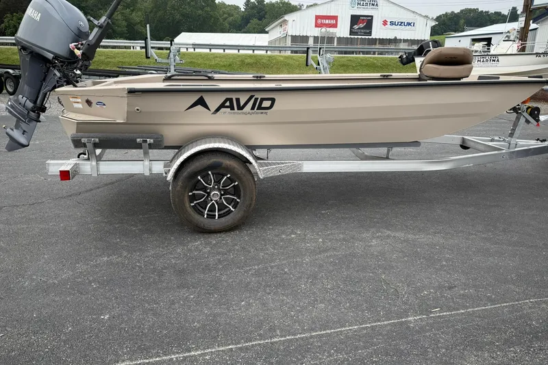 Slide: The Image of 2026 Avid 16 Commander boat on trailer with Yamaha motor, parked outdoors. - 4