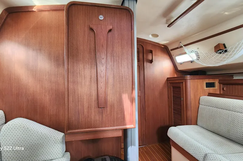 Slide: The Image of Interior of 2000 Island Packet 380 sailboat with wood paneling and cushioned seating. - 20