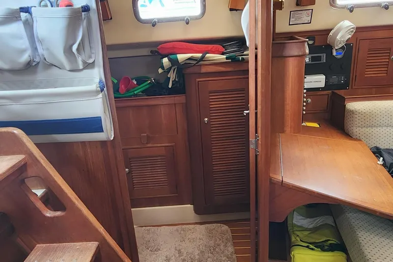 Slide: The Image of Interior of 2000 Island Packet 380 sailboat with wooden cabinetry and seating area. - 24