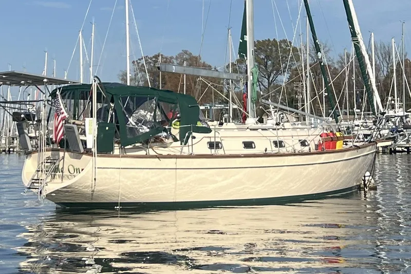 Slide: The Image of 2000 Island Packet 380 sailboat docked in a marina, featuring green canvas covers. - 3