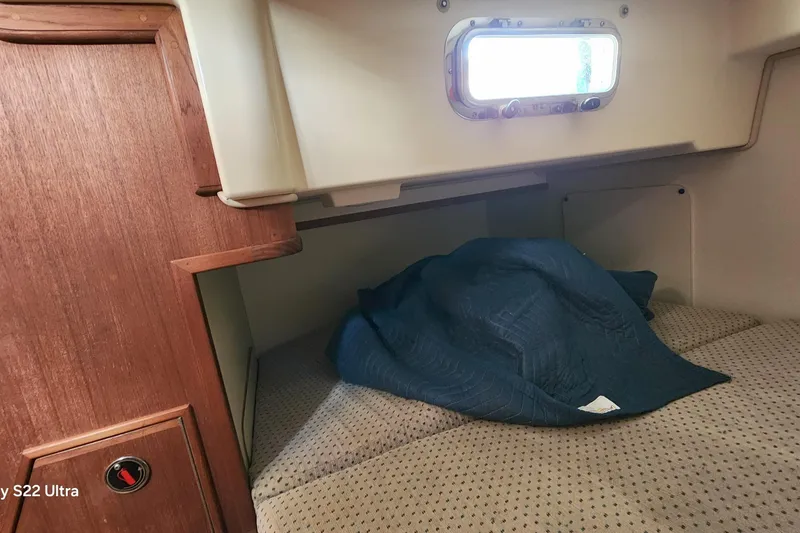 Slide: The Image of Cozy cabin interior of 2000 Island Packet 380 sailboat with bedding and porthole. - 30