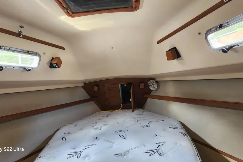 Slide: The Image of Cozy cabin interior of 2000 Island Packet 380 sailboat with mattress and portholes. - 32