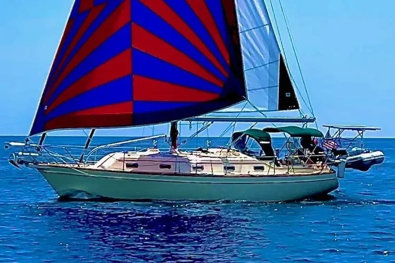 Slide: The Image of Sailing yacht Island Packet 380, 2000 model, with vibrant red and blue sails on open water. - 5