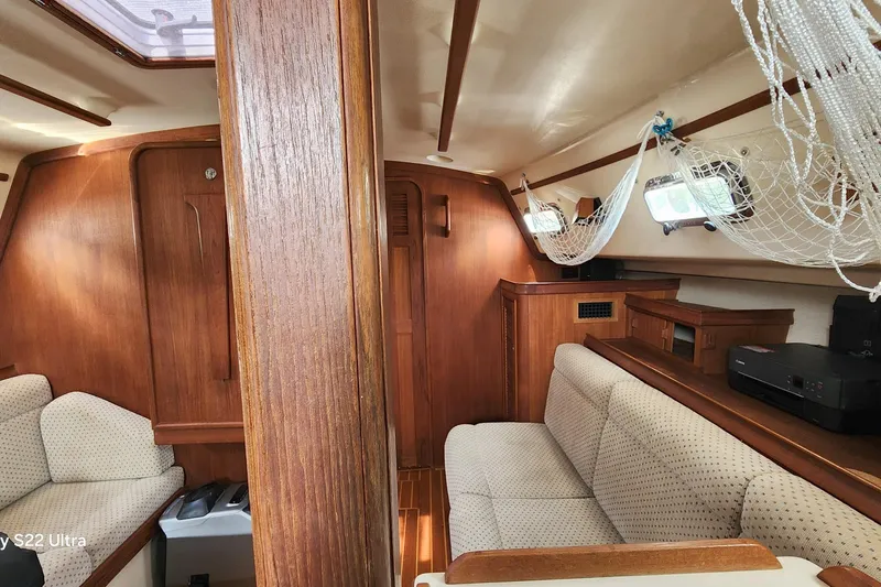 Slide: The Image of Interior of 2000 Island Packet 380 sailboat with wood finish and cozy seating. - 6