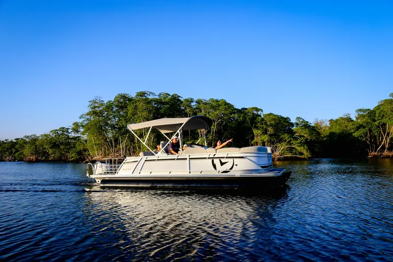 Slide: The Image of 2025 Vision Marine Technologies V24 boat cruising on a serene lake with lush greenery. - 3