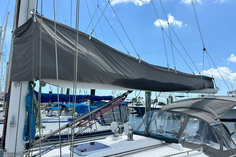 Slide: The Image of 2007 Sabre 386 sailboat with covered mainsail docked at marina under blue sky. - 13