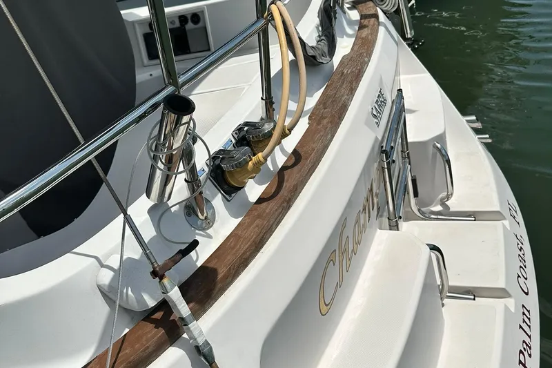 Slide: The Image of 2007 Sabre 386 sailboat stern with chrome fittings and wooden trim, docked in water. - 17