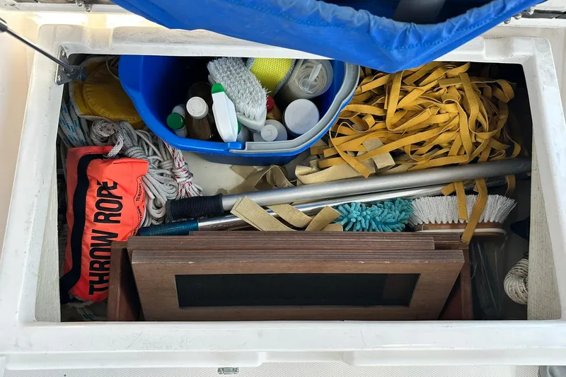 Slide: The Image of Storage compartment on a 2007 Sabre 386 boat with cleaning supplies and safety equipment. - 43
