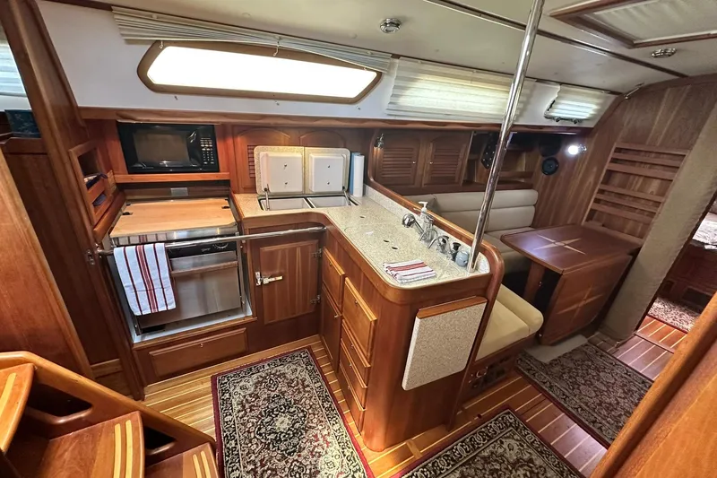 Slide: The Image of Luxurious 2007 Sabre 386 yacht interior with wood finish, kitchen, and seating area. - 55