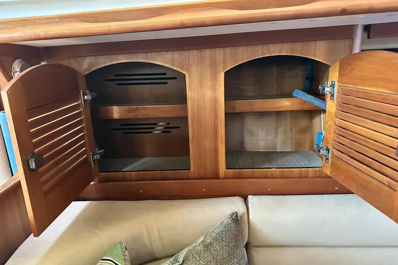 Slide: The Image of Wooden cabinet with open doors inside a 2007 Sabre 386 yacht, revealing storage space. - 66