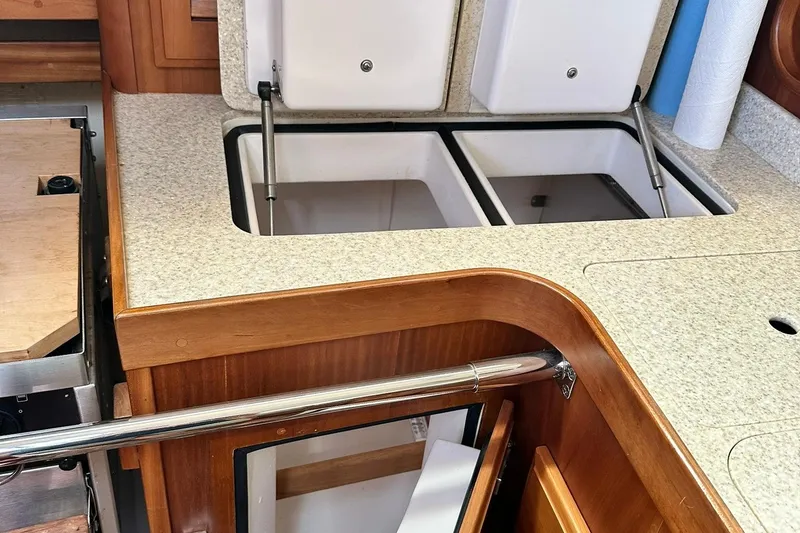 Slide: The Image of 2007 Sabre 386 yacht interior with open storage compartments and wooden cabinetry. - 76