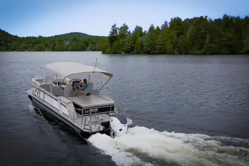 Slide: The Image of 2025 Vision Marine Technologies V24 boat cruising on a serene lake with lush green surroundings. - 13