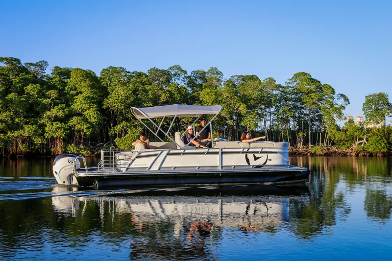 Slide: The Image of 2025 Vision Marine Technologies V24 electric boat cruising on calm water near lush greenery. - 6