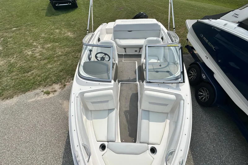 Slide: The Image of 2013 Regal 1900 Bowrider boat with white interior, parked on grass. - 12