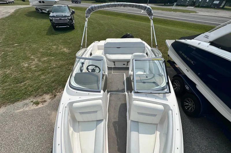 Slide: The Image of 2013 Regal 1900 Bowrider boat with open seating, parked on grass. - 13