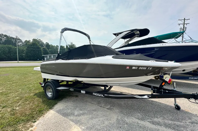Slide: The Image of 2013 Regal 1900 Bowrider boat on trailer, covered, parked outdoors. - 3