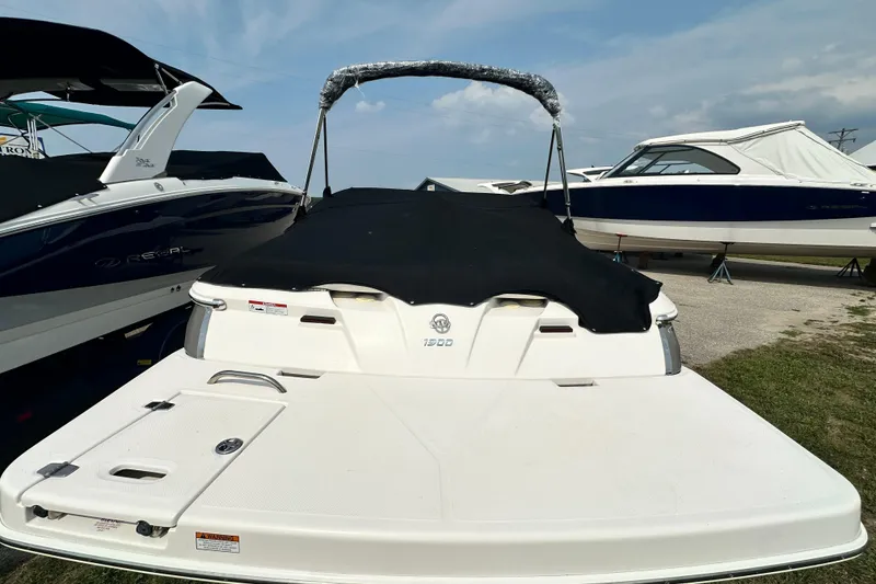 Slide: The Image of 2013 Regal 1900 Bowrider boat with black cover, parked outdoors. - 4