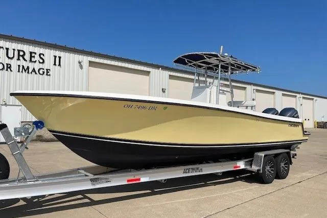 The Image of 2003 Contender 27 Open boat in a garage, yellow hull, on a trailer. - 0