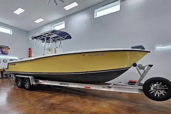 Slide: The Image of 2003 Contender 27 Open boat with dual Yamaha 225 engines in a garage. - 1