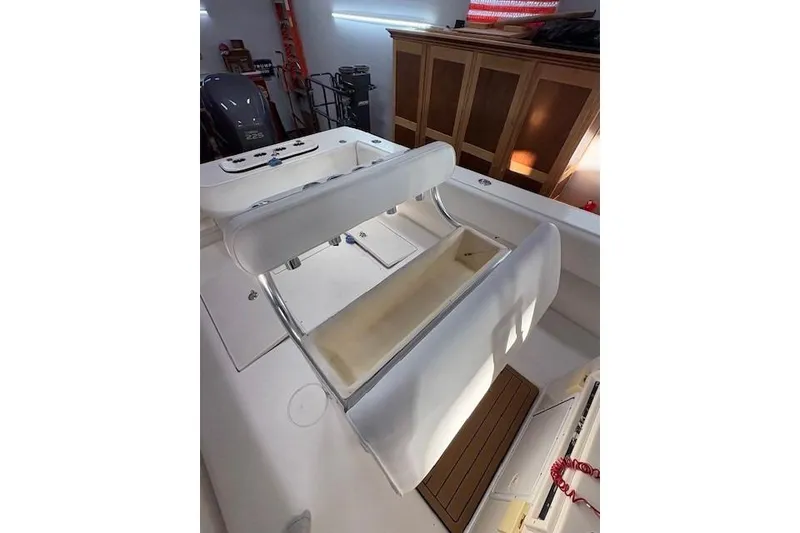 Slide: The Image of 2003 Contender 27 Open boat with blue cover in a well-lit garage. - 12