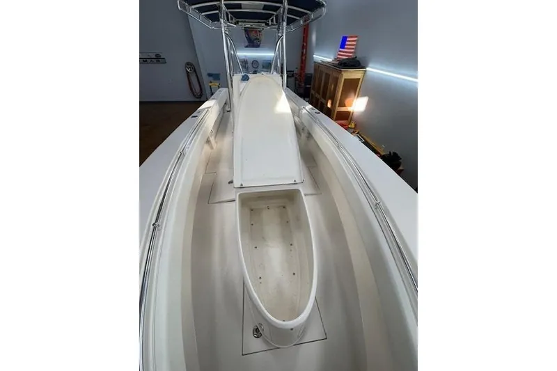 Slide: The Image of 2003 Contender 27 Open boat interior with console and rod holders in a garage. - 13