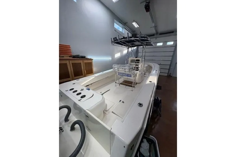 Slide: The Image of 2003 Contender 27 Open boat interior with white seating and storage compartments. - 14
