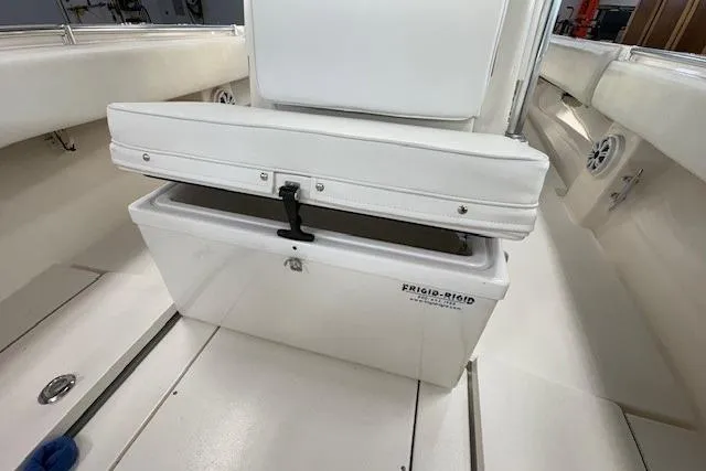 Slide: The Image of 2003 Contender 27 Open boat interior with seating and T-top in a garage setting. - 16