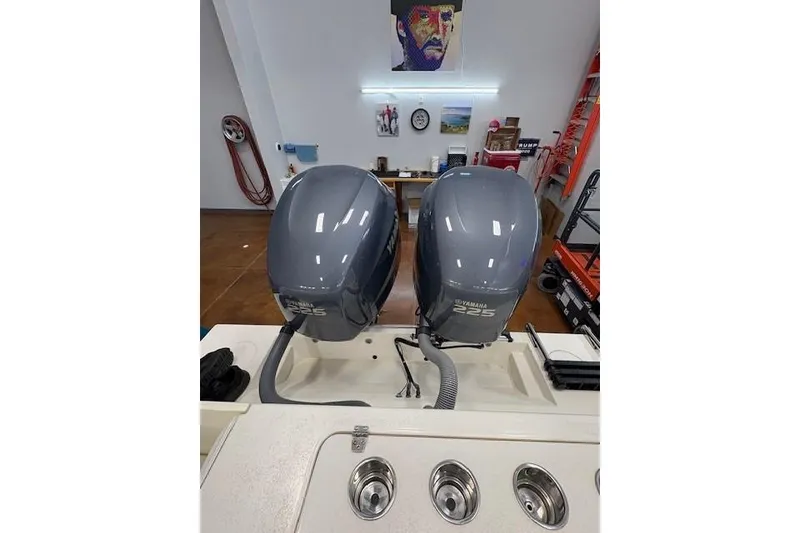 Slide: The Image of Twin Yamaha 225 outboard engines on a 2003 Contender 27 Open boat in a garage. - 18