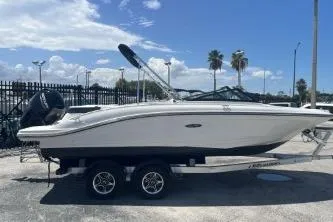The Image of 2022 Sea Ray SPX 210 Outboard boat on trailer, parked outdoors under blue sky. - 0