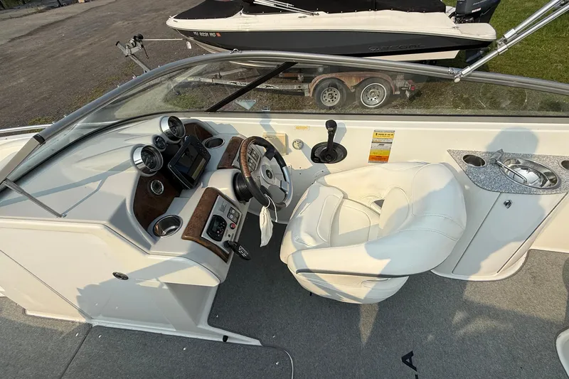 Slide: The Image of 2007 Formula 240 BR boat interior with steering wheel, gauges, and white captain's chair. - 2