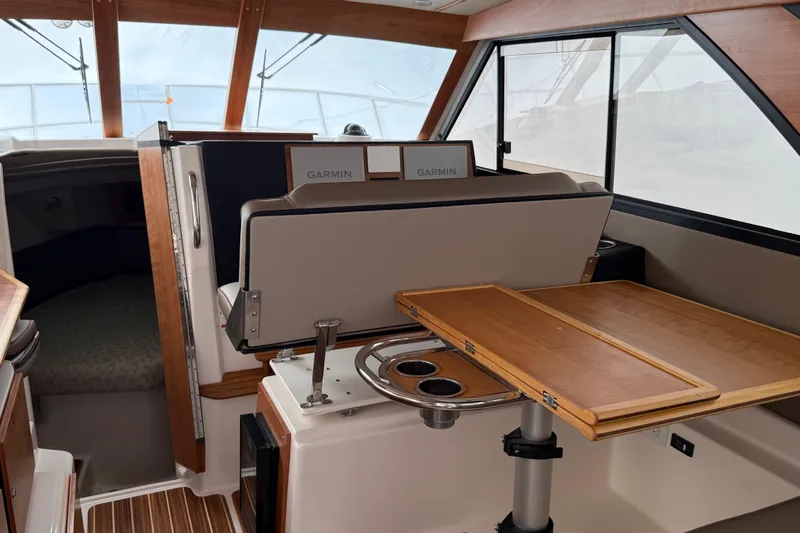 Slide: The Image of Interior of 2025 Cutwater C-32 CB boat with Garmin navigation and wooden table. - 14