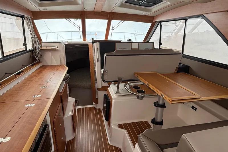 Slide: The Image of 2025 Cutwater C-32 CB interior with wood finishes and modern navigation equipment. - 15