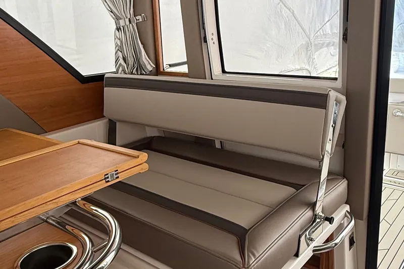 Slide: The Image of Interior of 2025 Cutwater C-32 CB boat with cushioned seating and wooden table. - 20